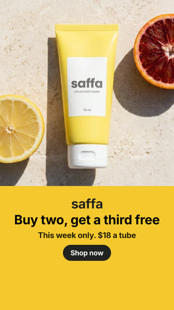 An image ad: a yellow hand cream tube on sunlit travertine between a halved lemon and a blood orange, with “Buy two, get a third free” and a Shop now button on a yellow band below.